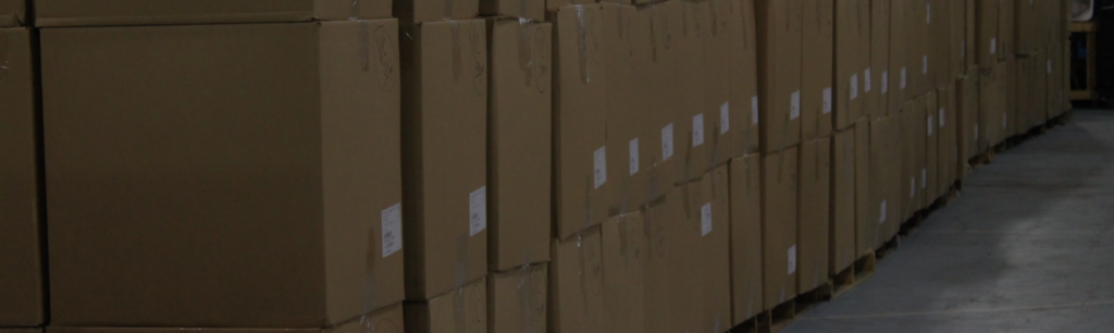Boxed designer footwear stacked in a wholesale warehouse